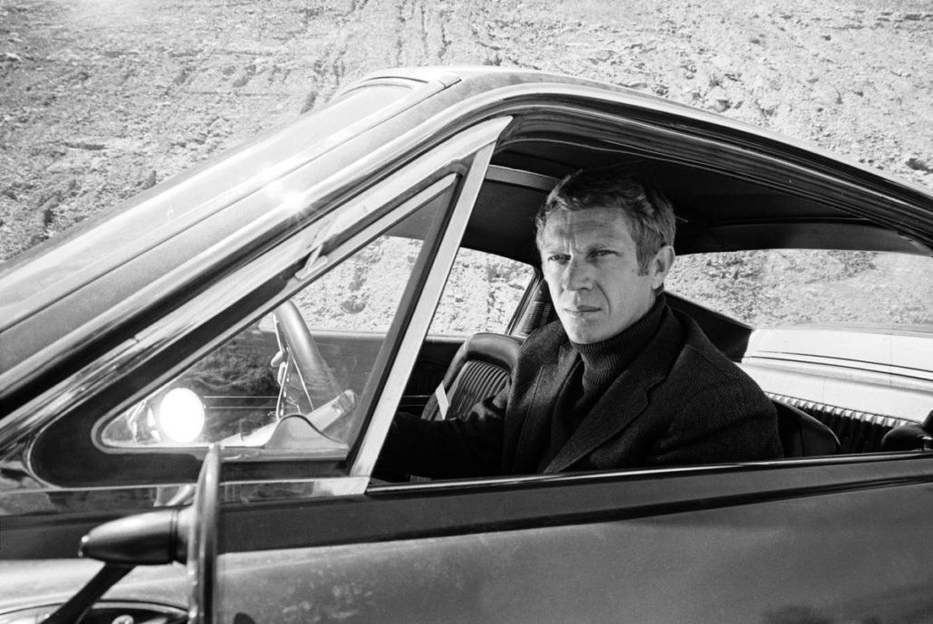McQueen portant un col roulé monochrome avec sa veste, un style qui est de nouveau populaire en ce moment