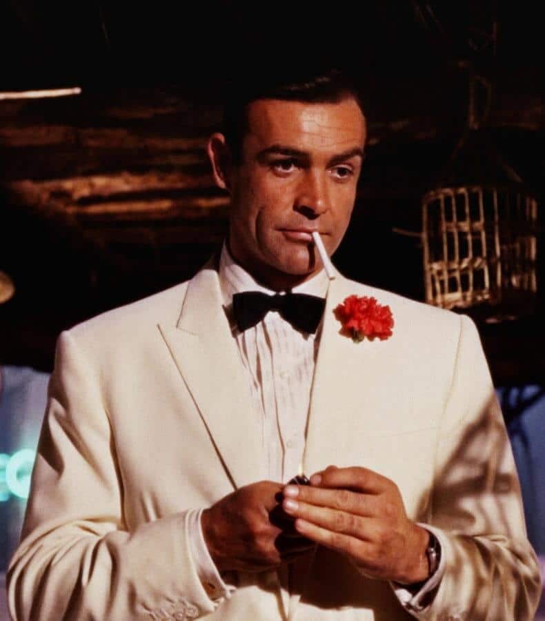 Sean Connery comme James Bond portant une veste blanche avec une boutonnière d'oeillets rouges