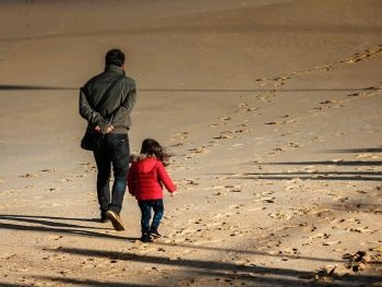 Père et fille marchant sur la plage