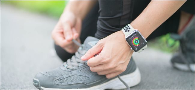 Une femme attachant ses lacets tout en portant une Apple Watch.