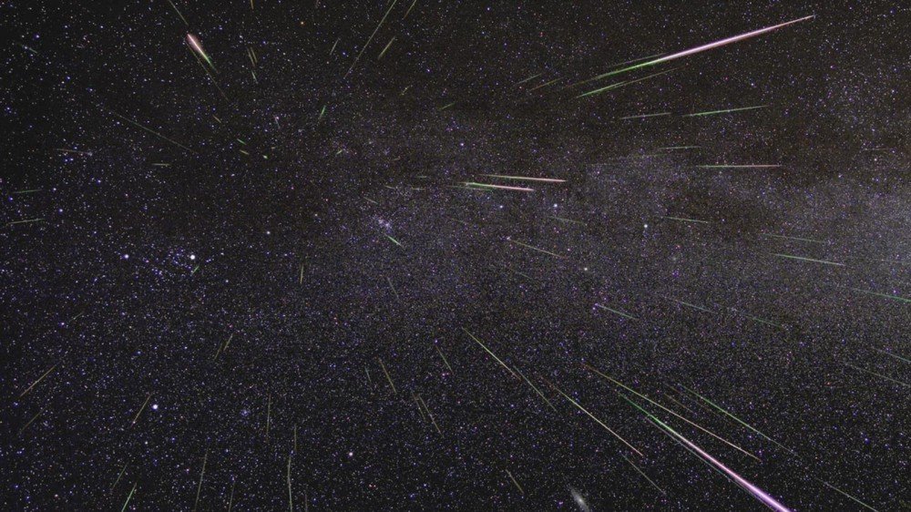 Les météores traversent un ciel sombre et étoilé.