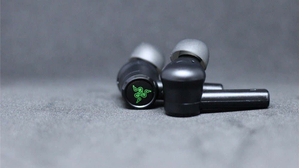 Les écouteurs Razer Hammerhead Pro avec un accent sur le pavé tactile et le logo Razer triple serpent