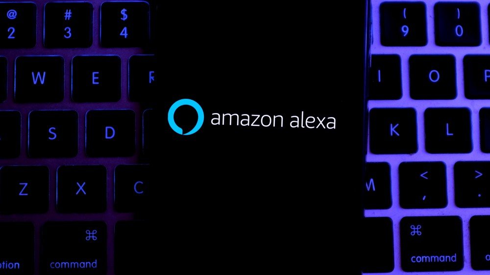 Amazon Alexa sur un iPhone reposant sur un clavier MacBook.