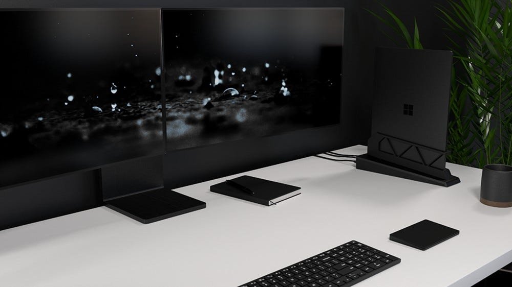 Un ordinateur portable Surface ancré et connecté à deux moniteurs.