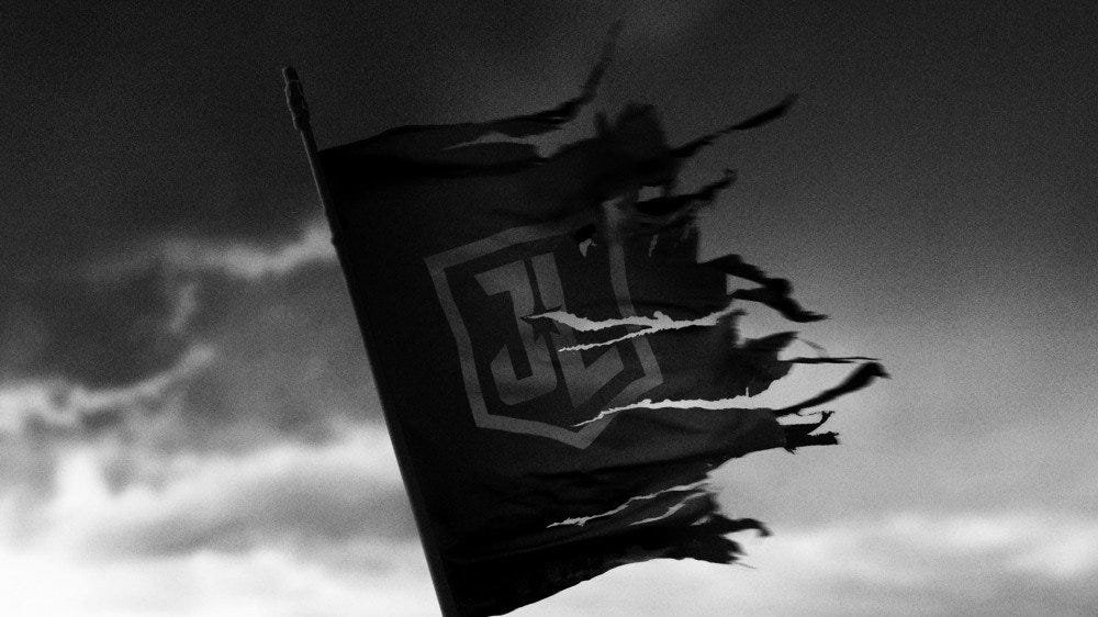 Une cape déchirée de style Superman avec les lettres JL, suspendue à un mât.