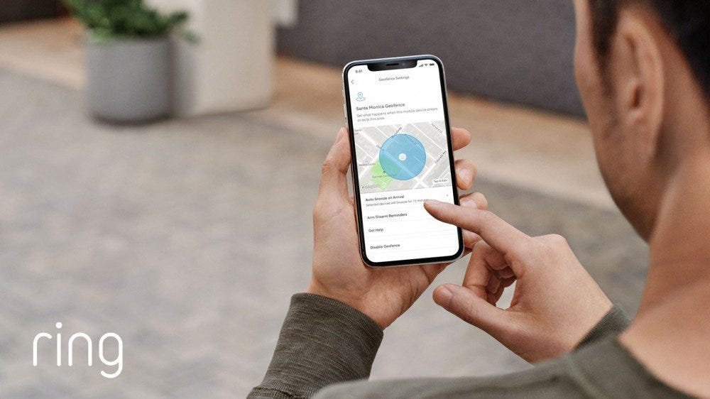 Un homme regarde une application Ring avec une clôture de géolocalisation autour de sa maison.