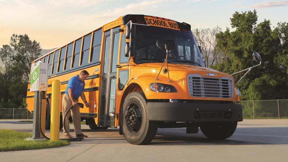 Un autobus scolaire électrique, branché sur un chargeur.