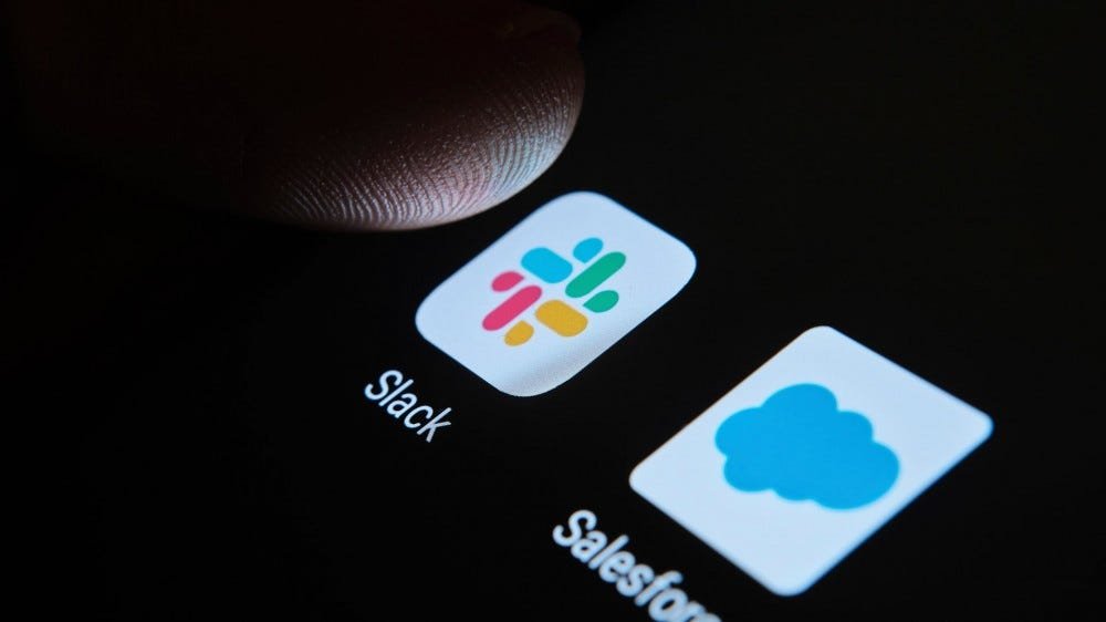 Un écran sombre avec une icône Slack et un doigt le touchant presque.