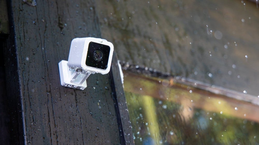 Une Wyze Cam v3 à l'extérieur sous la pluie.