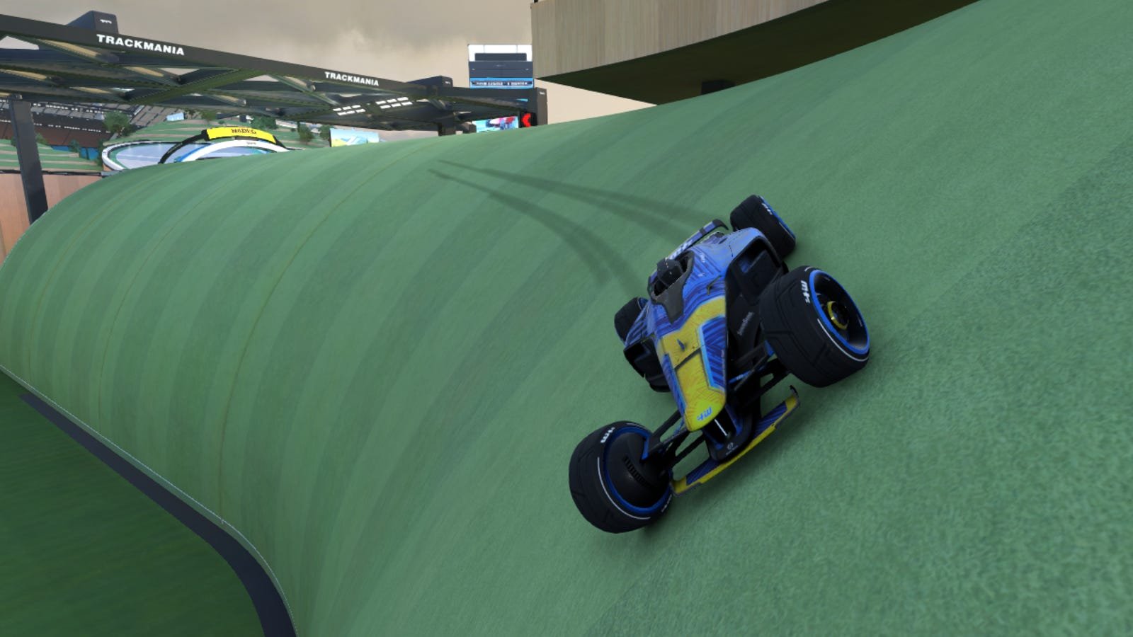 Course de voitures le long d'une colline herbeuse dans 'Trackmania'
