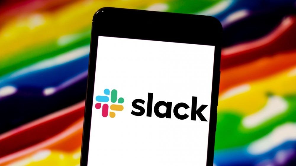 Logo de l'application Slack affiché sur l'écran du smartphone sur fond arc-en-ciel