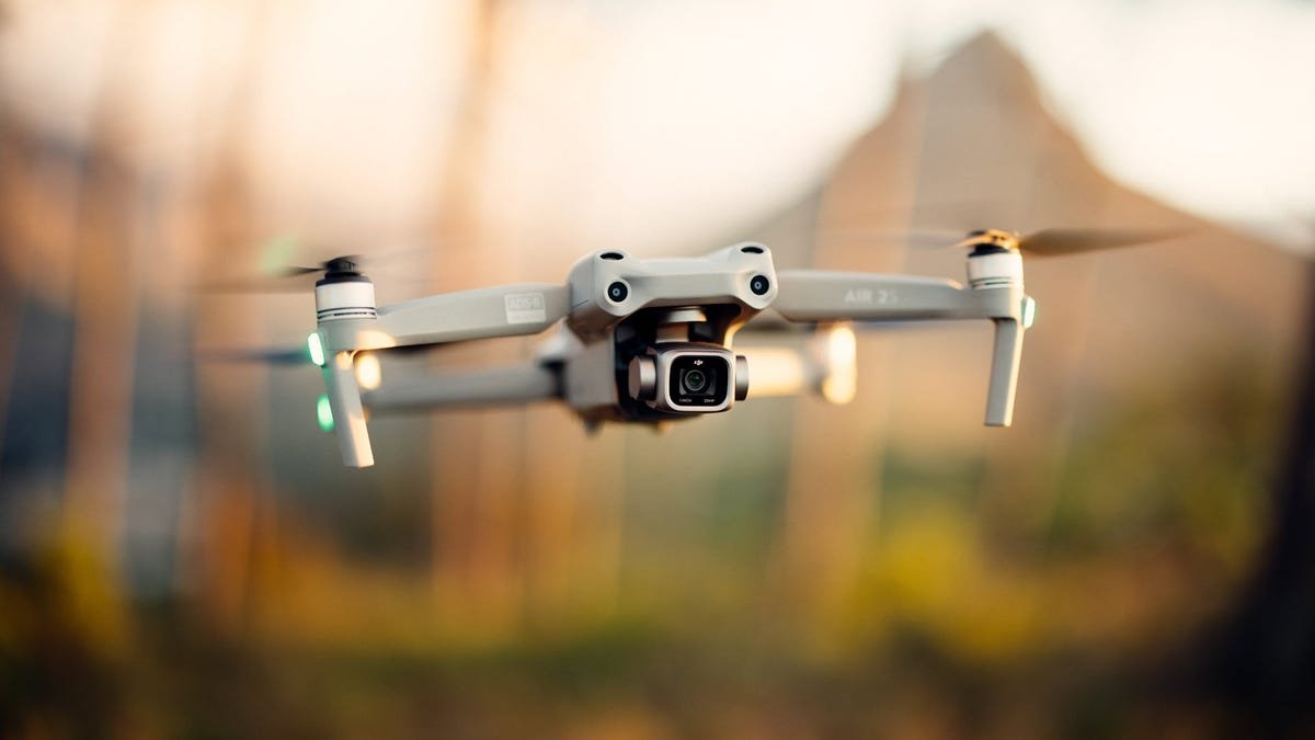 Un drone DJI Air 2S flottant dans un champ agricole.