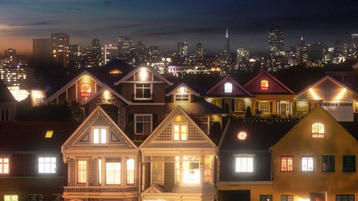 Une rue pleine de maisons la nuit.