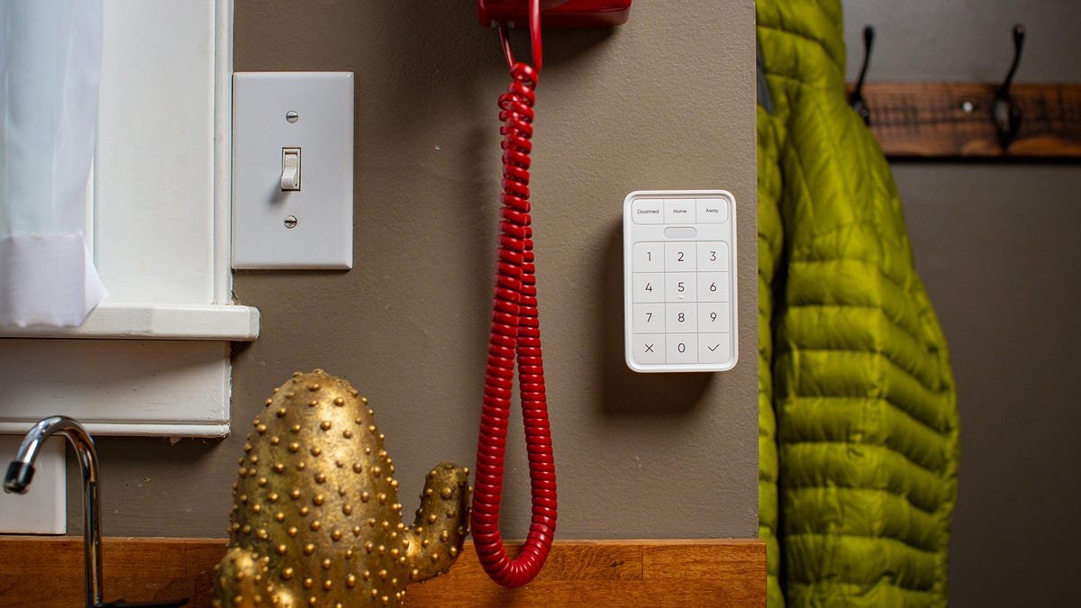 Un clavier Wyze à côté d'un porte-manteau.