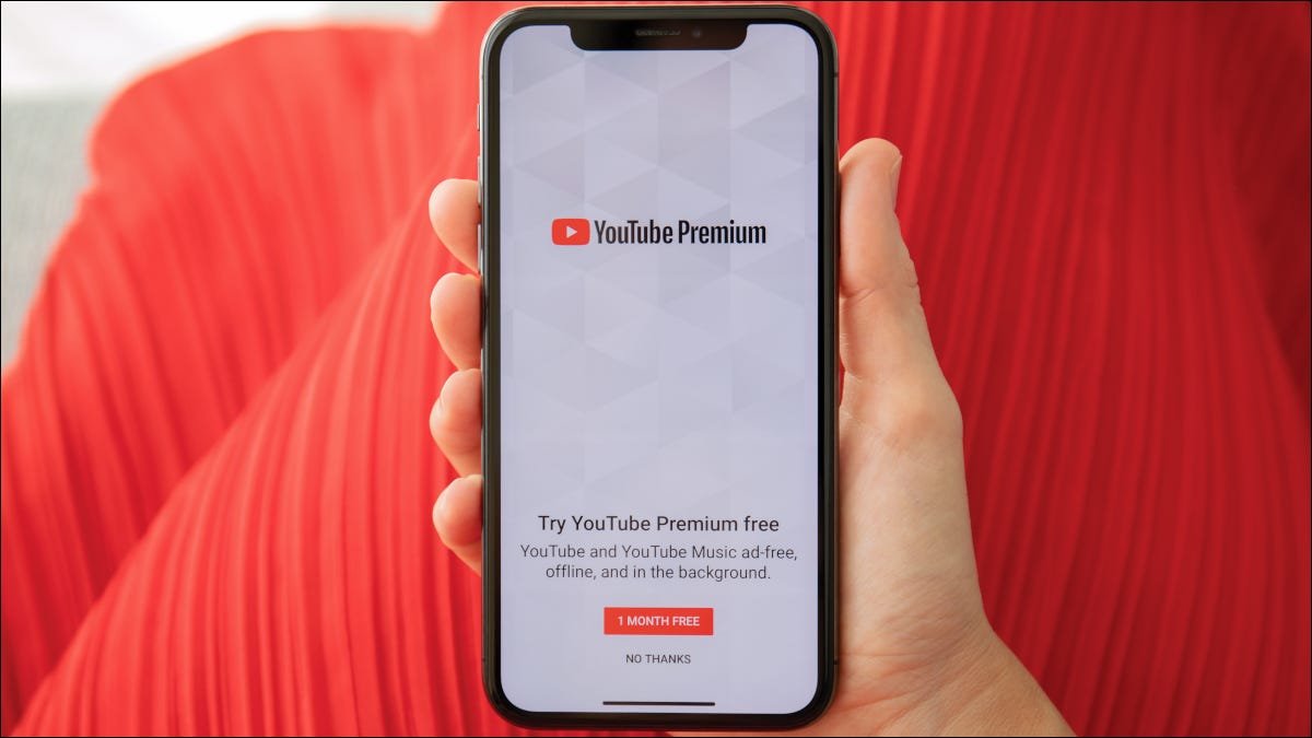 Main tenant un smartphone montrant la page d'inscription YouTube Premium