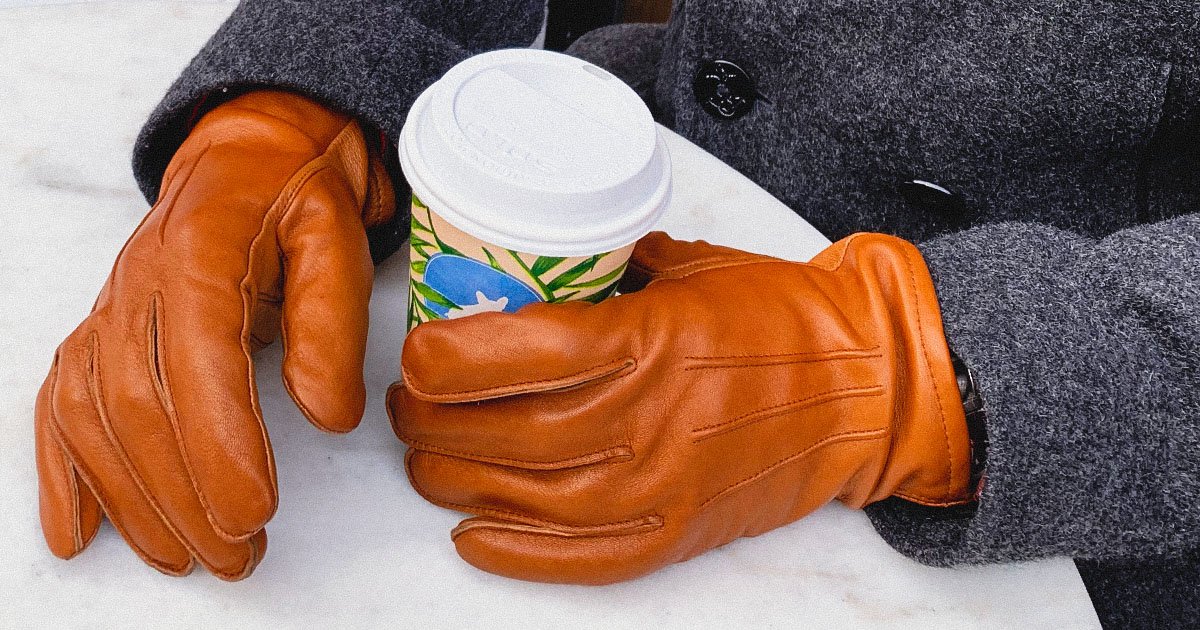 homme portant des gants en cuir tenant un café