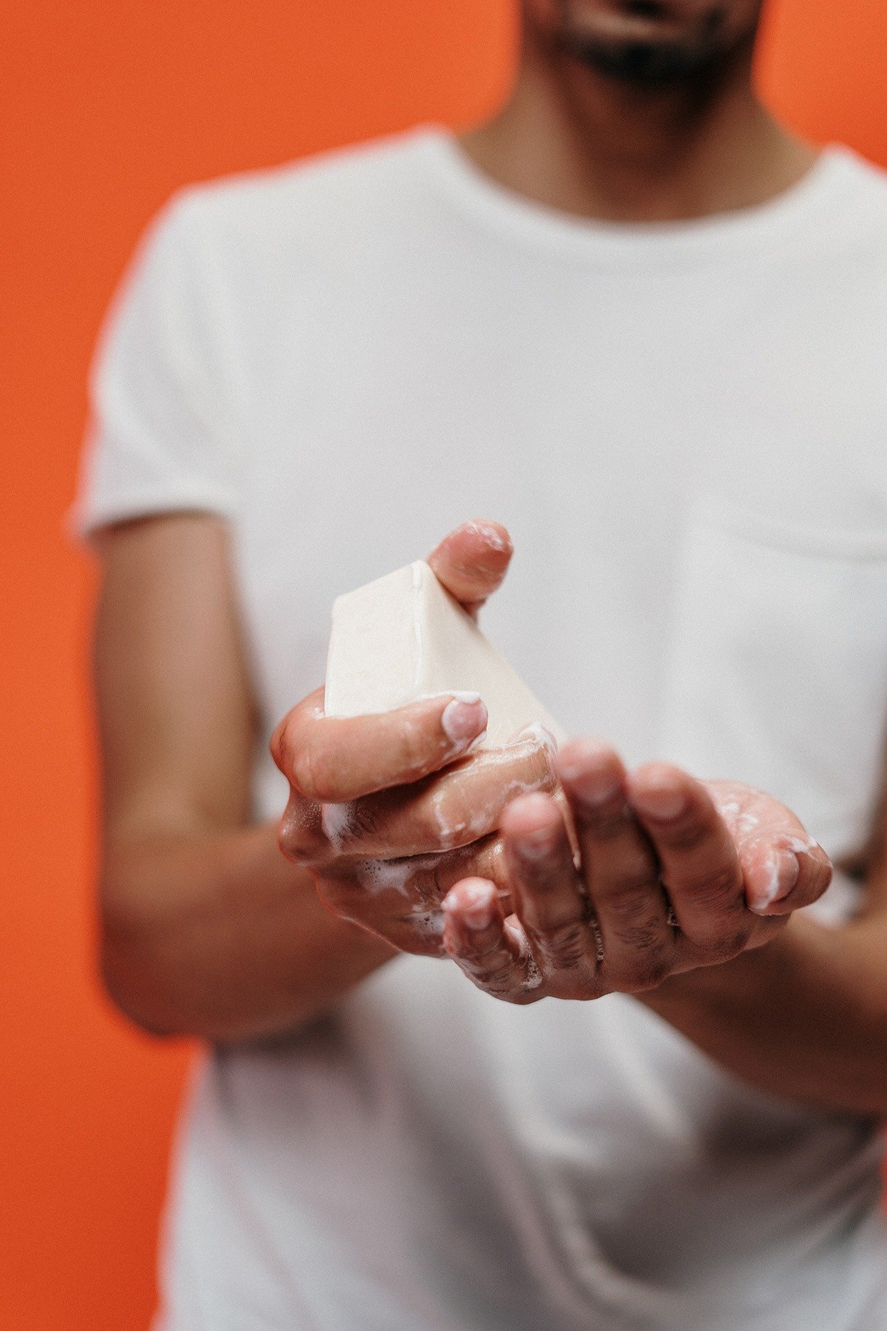 homme en tshirt blanc se laver les mains avec du savon