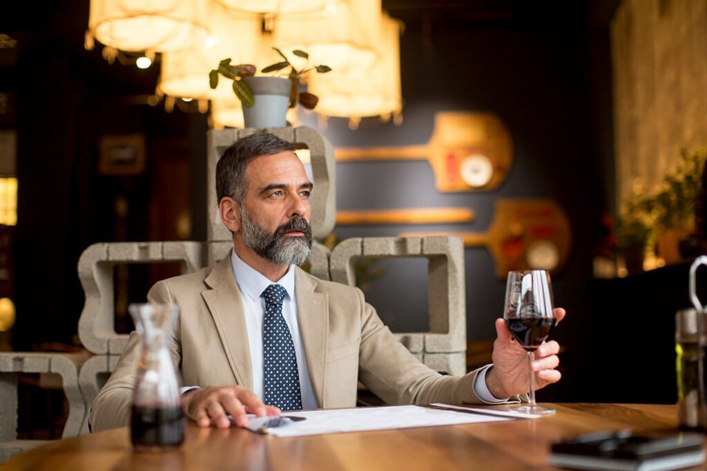 homme en costume beige dans un restaurant assis