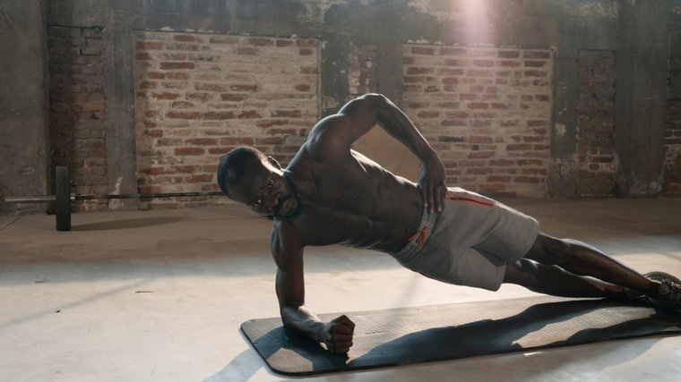 Homme musclé effectuant un exercice ab sur le sol