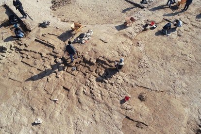 Des archéologues et des ouvriers découvrent les murs en briques crues des bâtiments de la ville antique de Kemune