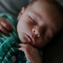 Libre d'un bébé garçon unique dormir en pyjama rayé vert et blanc