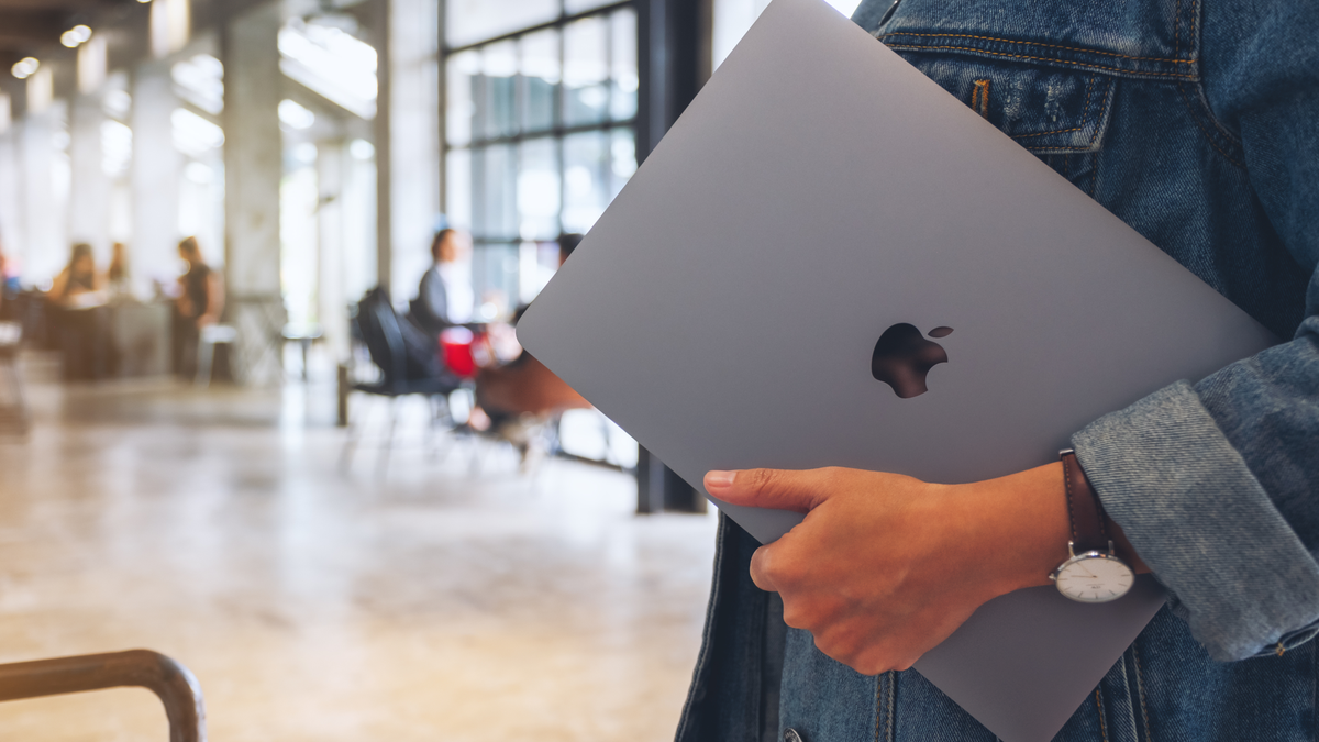 MacBook dans la main d'un utilisateur en marchant