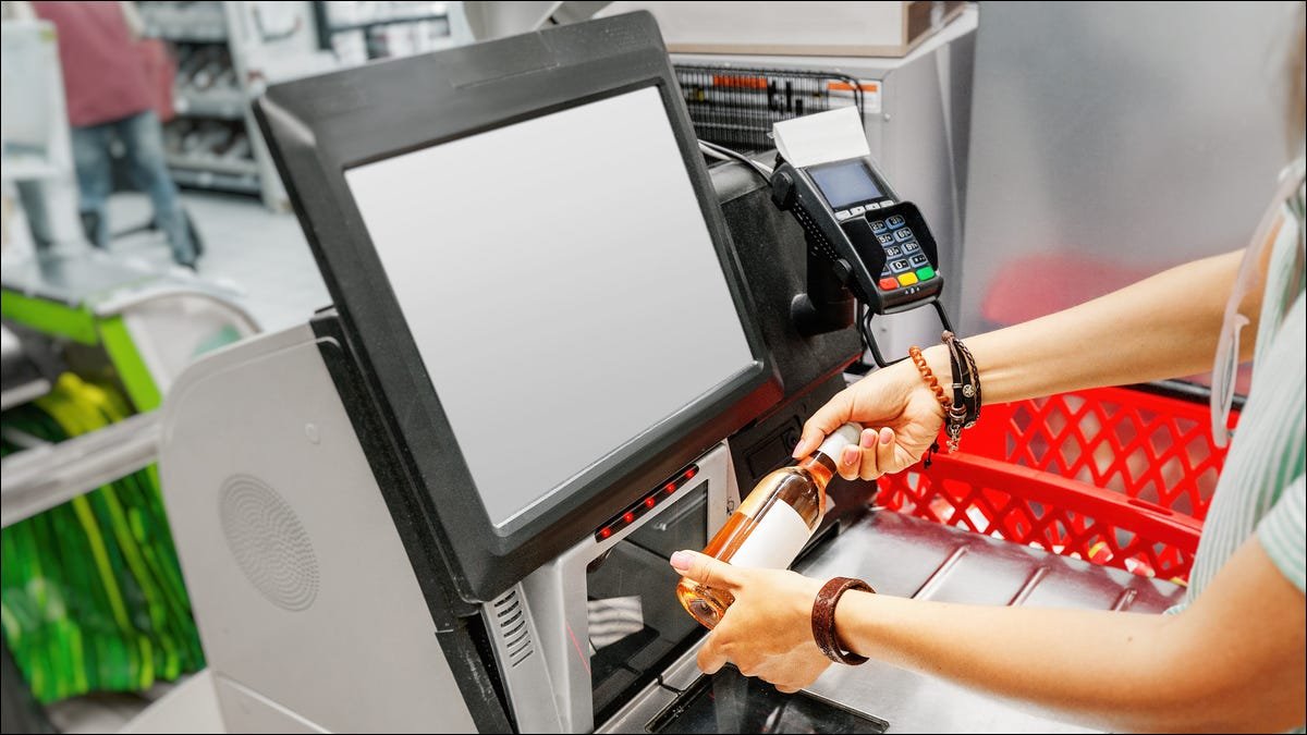 Numérisation d'une bouteille de vin dans une caisse automatique.