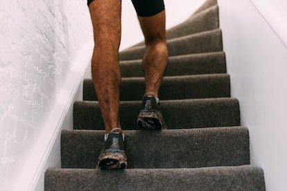 Gros plan d'un homme qui monte les escaliers à la maison.