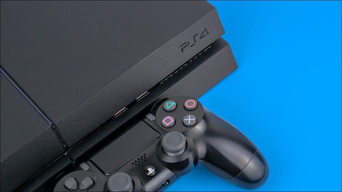 Une console Sony PS4 avec un contrôleur DualShock à côté sur un fond bleu.