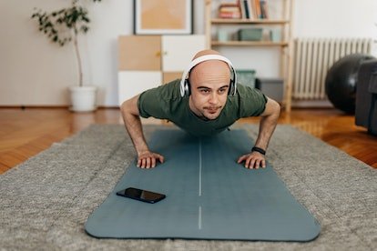 Homme faisant des pompes à la maison sur un tapis de yoga.