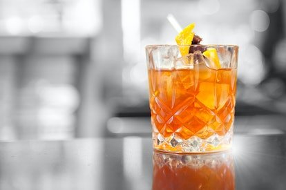 Un cocktail Negroni dans un verre posé sur une table 