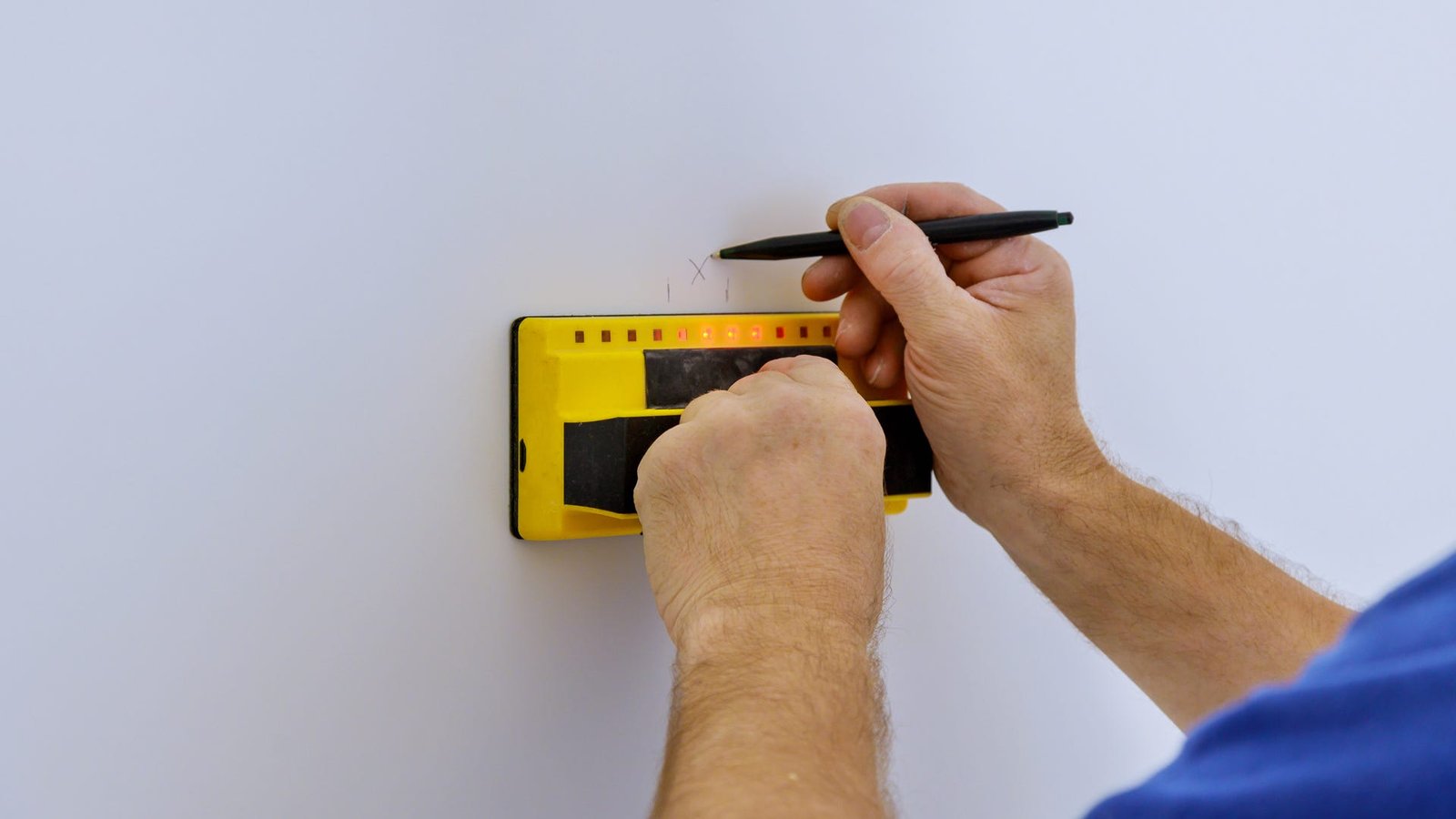 Homme utilisant un détecteur de montants sur un mur