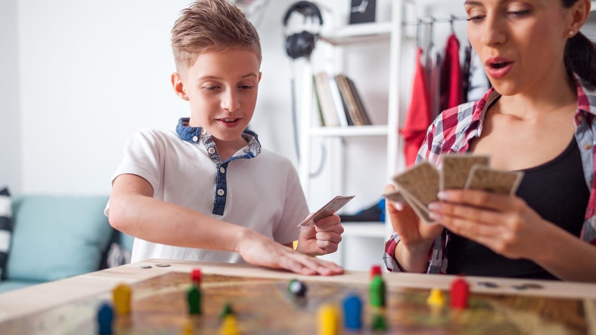 Une mère et son enfant jouent à un jeu de société.