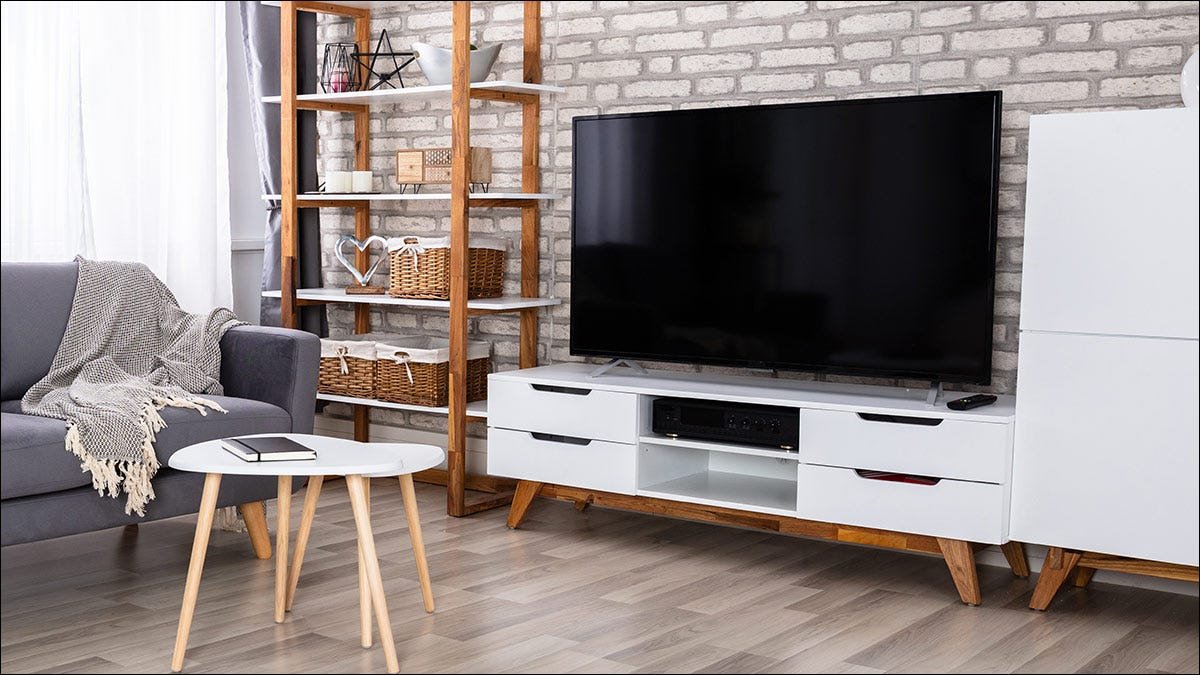 Un salon ensoleillé avec une télévision et une console multimédia.