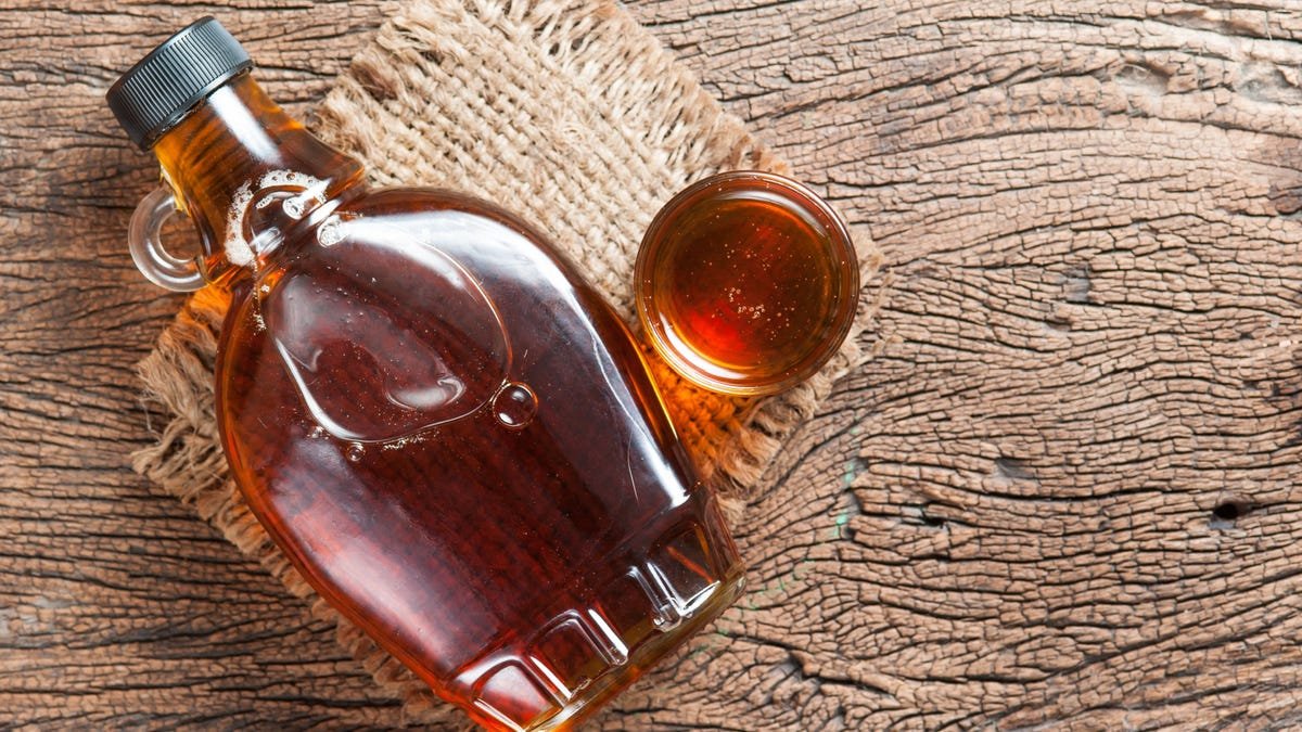 Sirop d'érable en bouteille de verre sur table en bois.