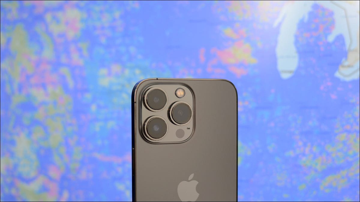 Un smartphone tenu devant une carte de déploiement cellulaire.