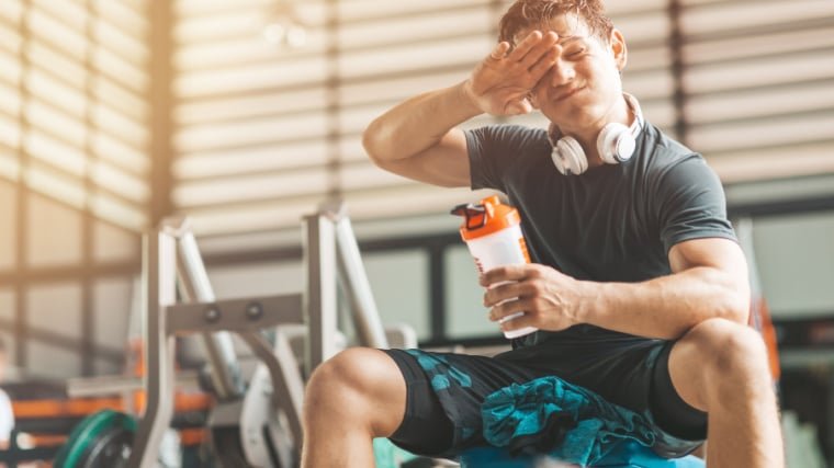 Personne dans la salle de sport transpirant en buvant avant l'entraînement.