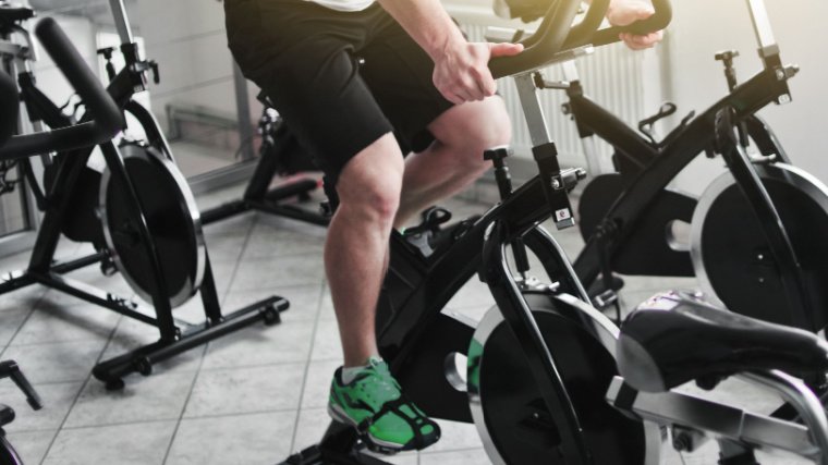 Personne dans une salle de sport sur un vélo de spinning