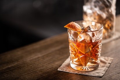 Un cocktail à l'ancienne posé sur un bar en bois