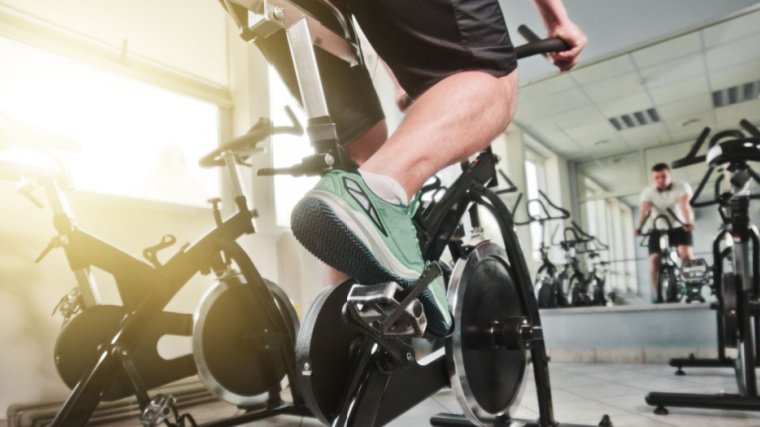 Personne dans une salle de sport utilisant un vélo de spinning