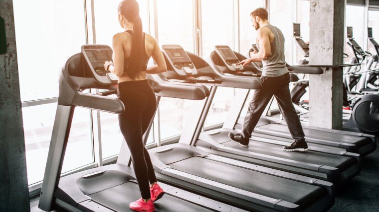 Gens dans une salle de sport sur des tapis roulants