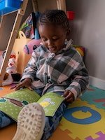 Lethukuthula Bhengu, trois ans, lit un livre chez ses parents à Johannesburg le 13 mai 2023...
