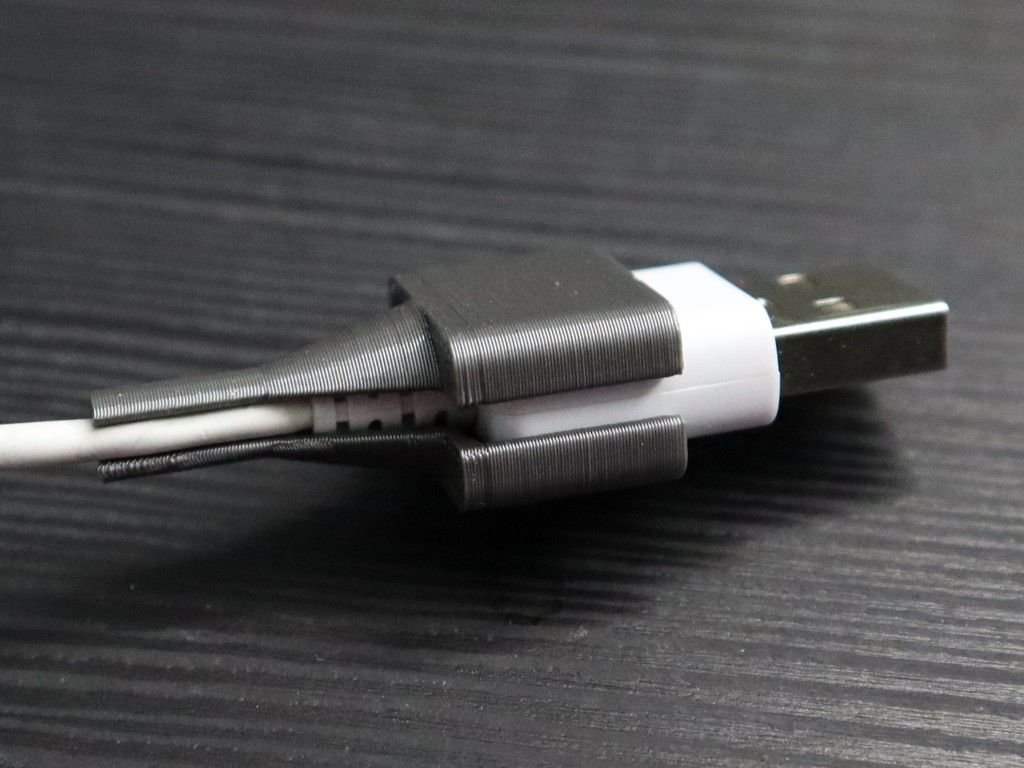 Économiseur de câble gris foncé imprimé en 3D enroulé autour d'un connecteur USB-A blanc