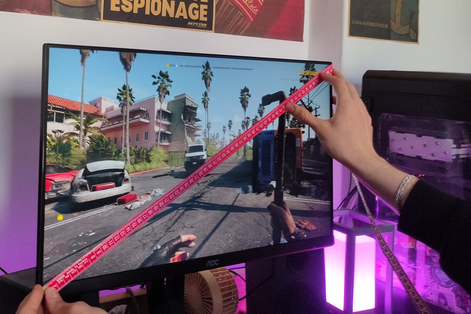 Une personne tenant un ruban rouge en diagonale sur un moniteur AOC.
