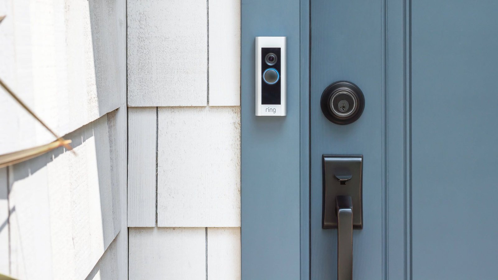 Une sonnette vidéo Ring montée sur un cadre de porte.