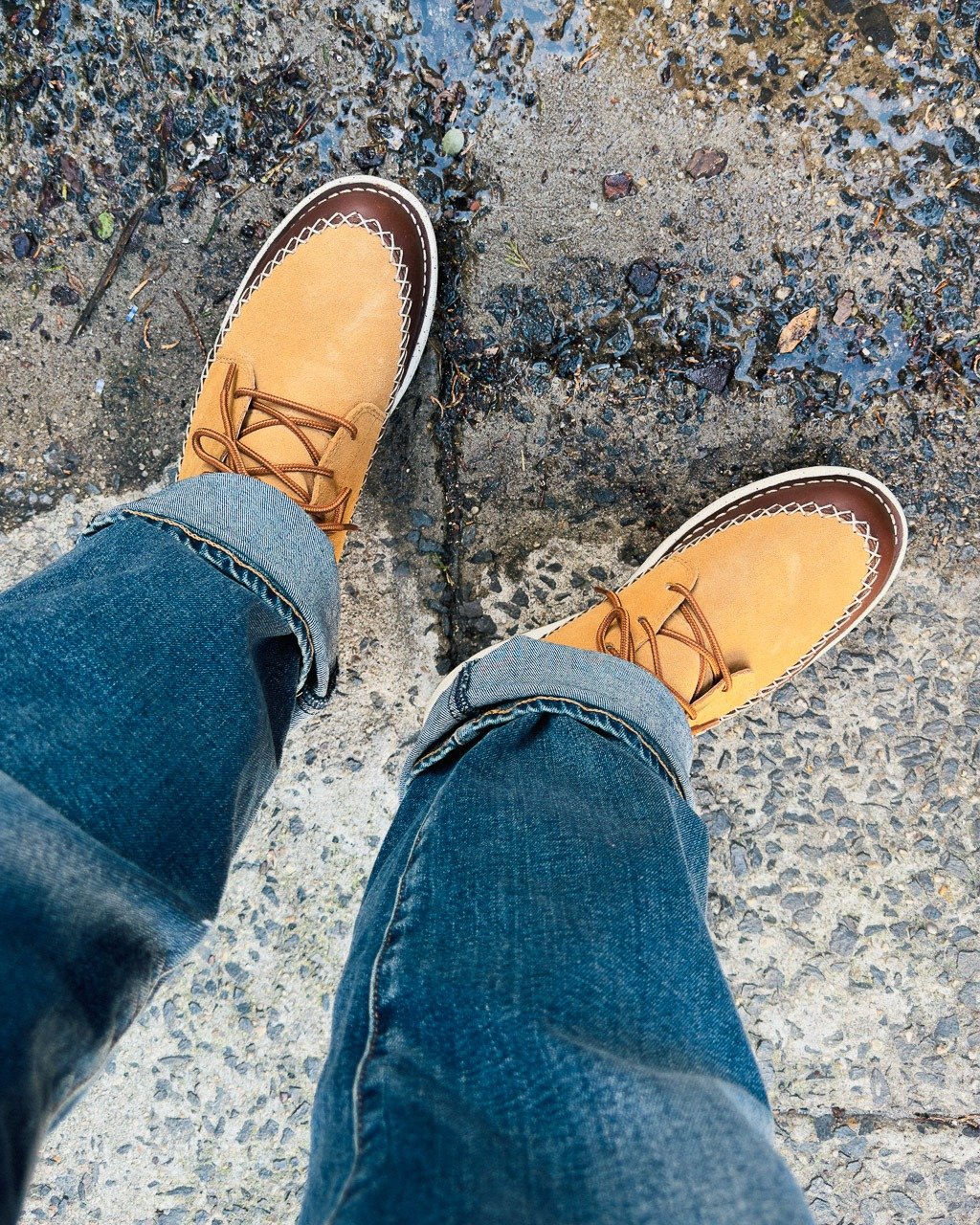 Gros plan de haut en bas de bottes en daim beige et en cuir marron avec coutures contrastées