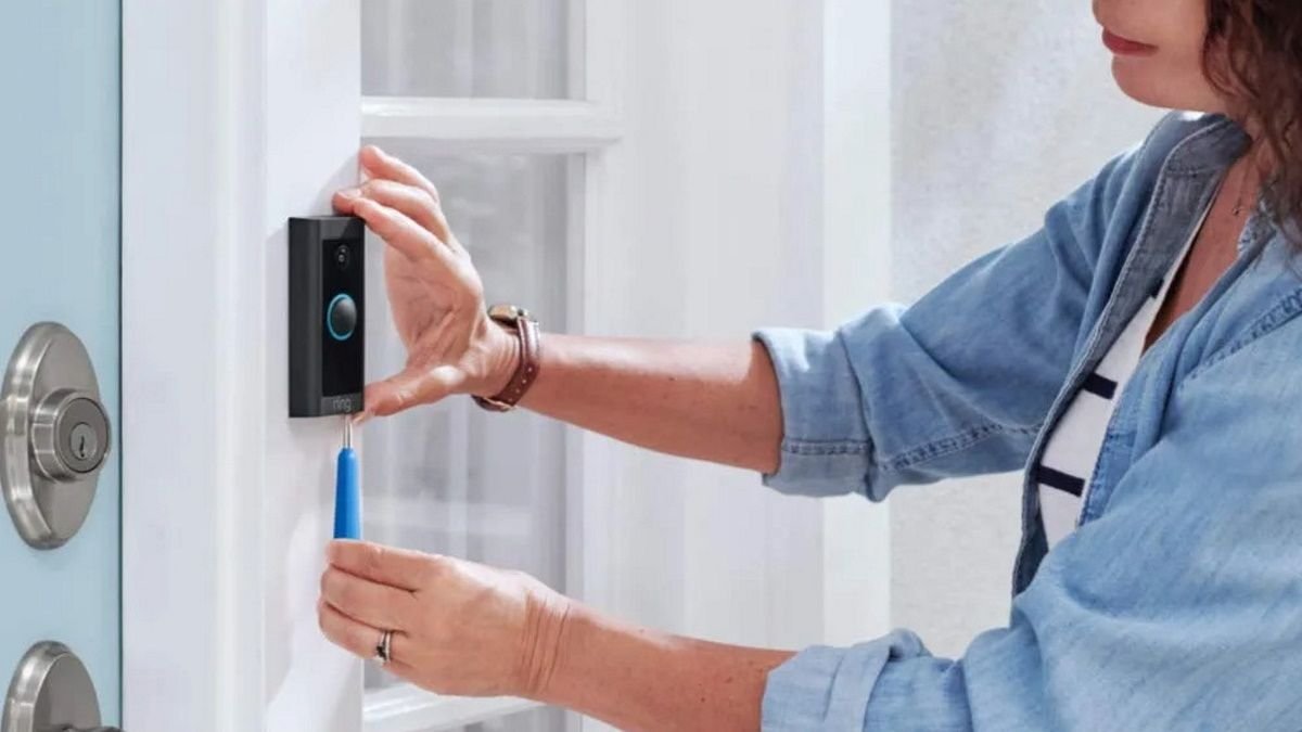Quelqu’un installe une sonnette vidéo Ring filaire.
