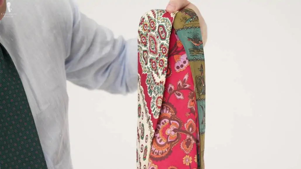 Raphaël montrant sa collection de cravates anciennes aux motifs audacieux.