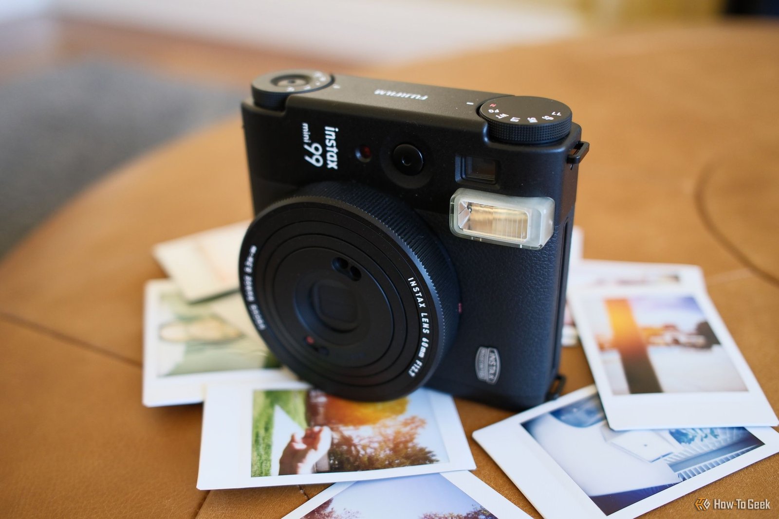 Vue latérale du Fujifilm Instax Mini 99 avec photos en dessous