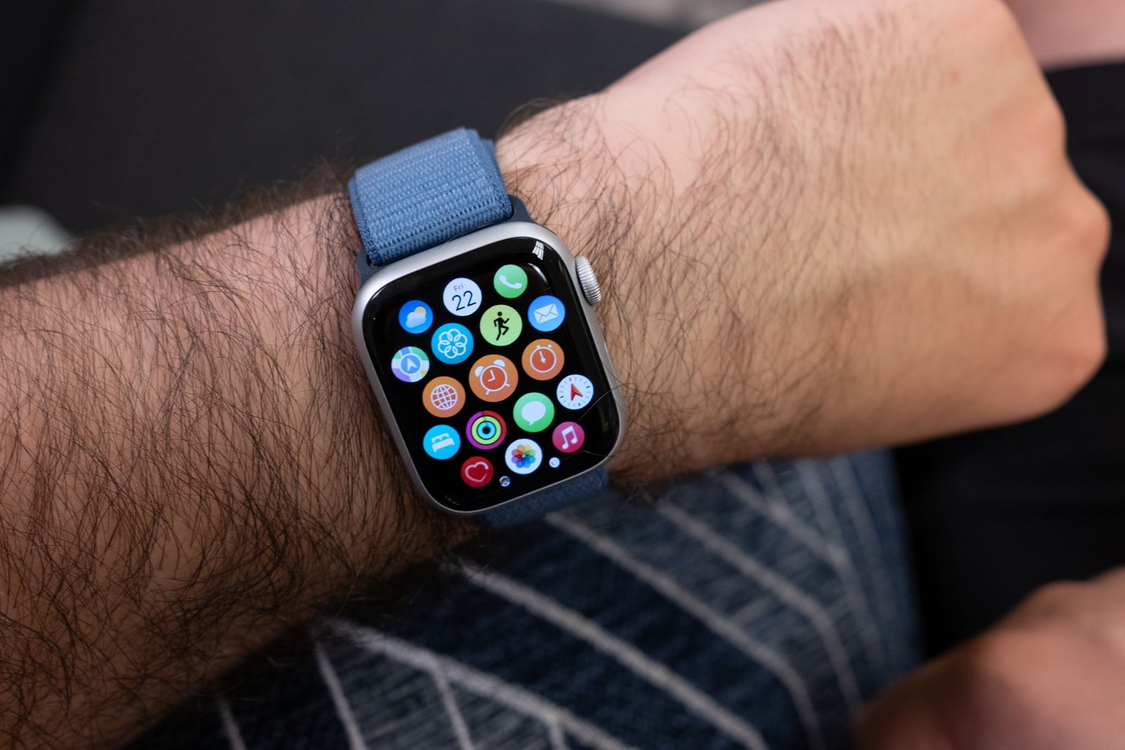Une personne portant une Apple Watch Series 9 avec le menu des applications affiché.